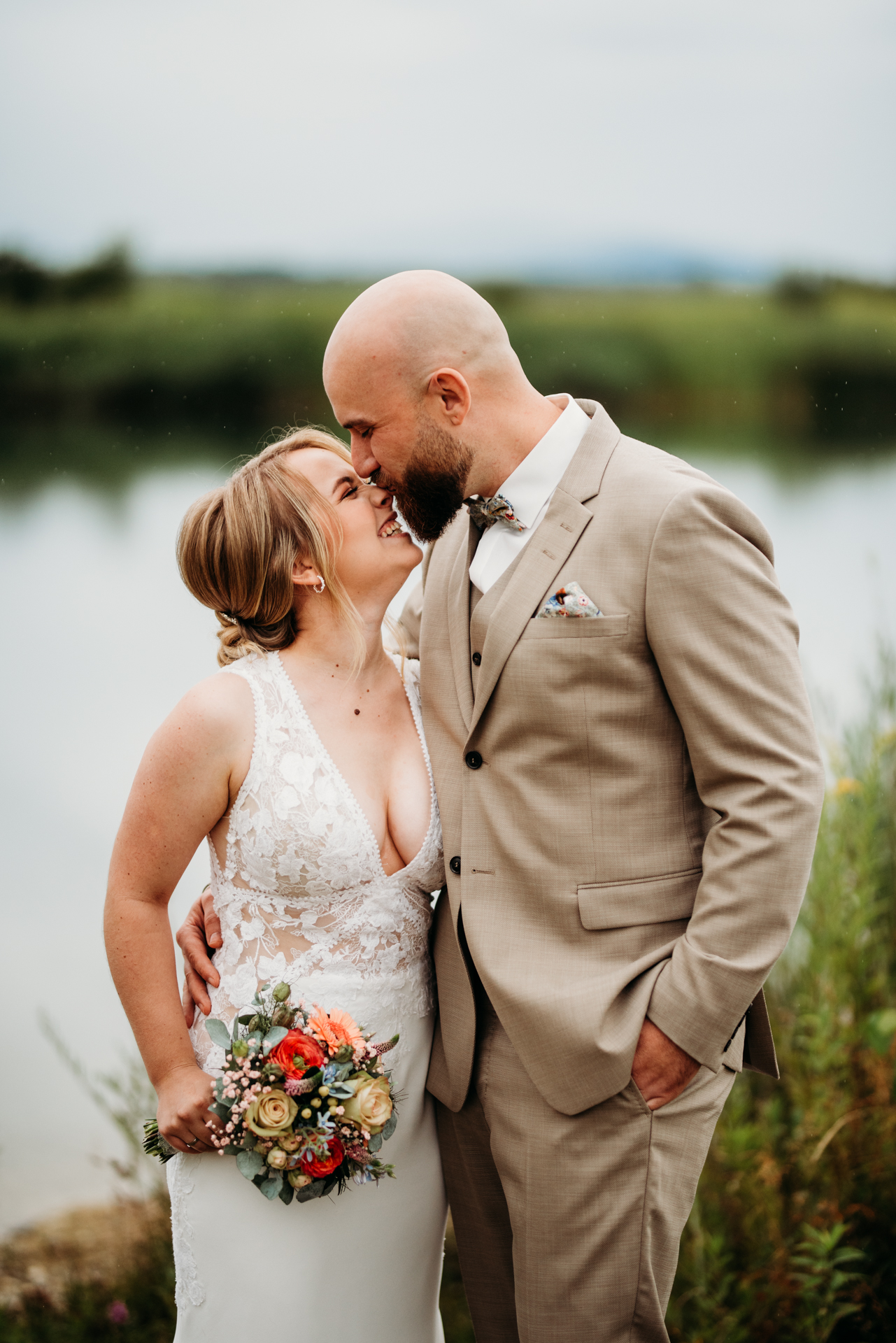 Wedding couple laughing in nature, approaching each other. kissing and cuddling.