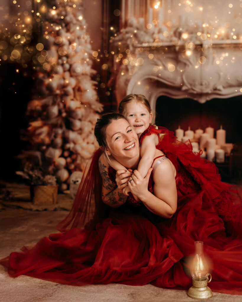 Weihnachtsshooting Reutlingen Studio – festliche Kulisse in Rot, Gold und Beige mit moody Fine-Art Licht, elegante Weihnachtsdekoration, luxuriöses Mini-Shooting-Set. girl picture red gown torch